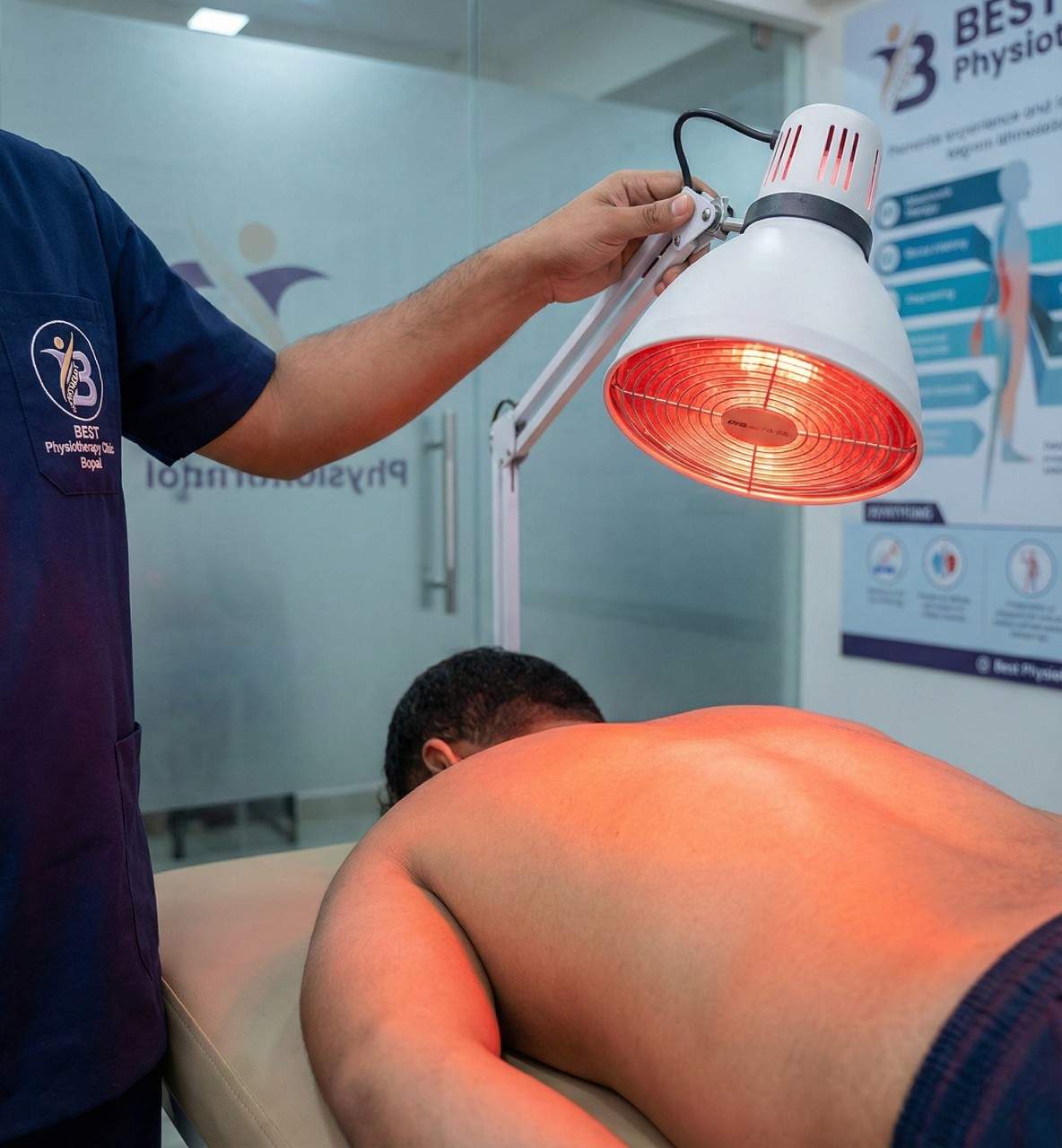 Close-up of an infrared heat lamp providing therapeutic warming treatment on the patient’s back.