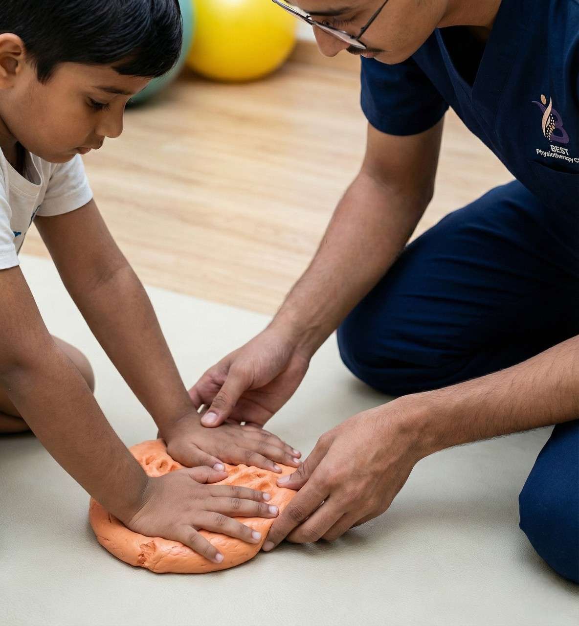 Physiotherapist helping a child with tactile sensory activity using therapeutic putty.