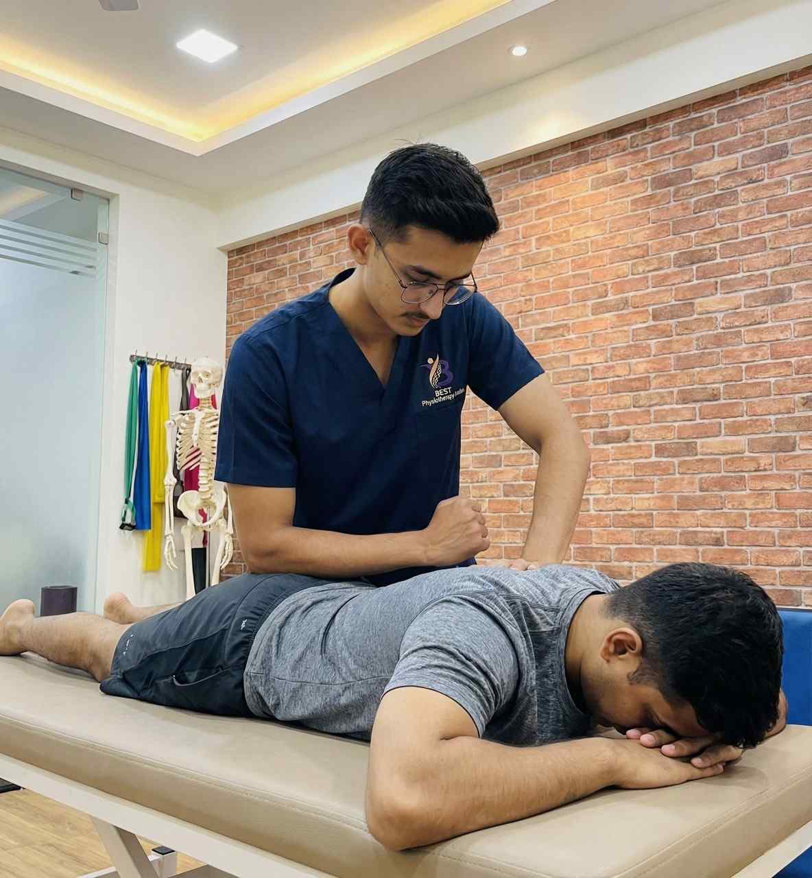 Dr. Kanaiya performing deep trigger point therapy on patient’s upper back