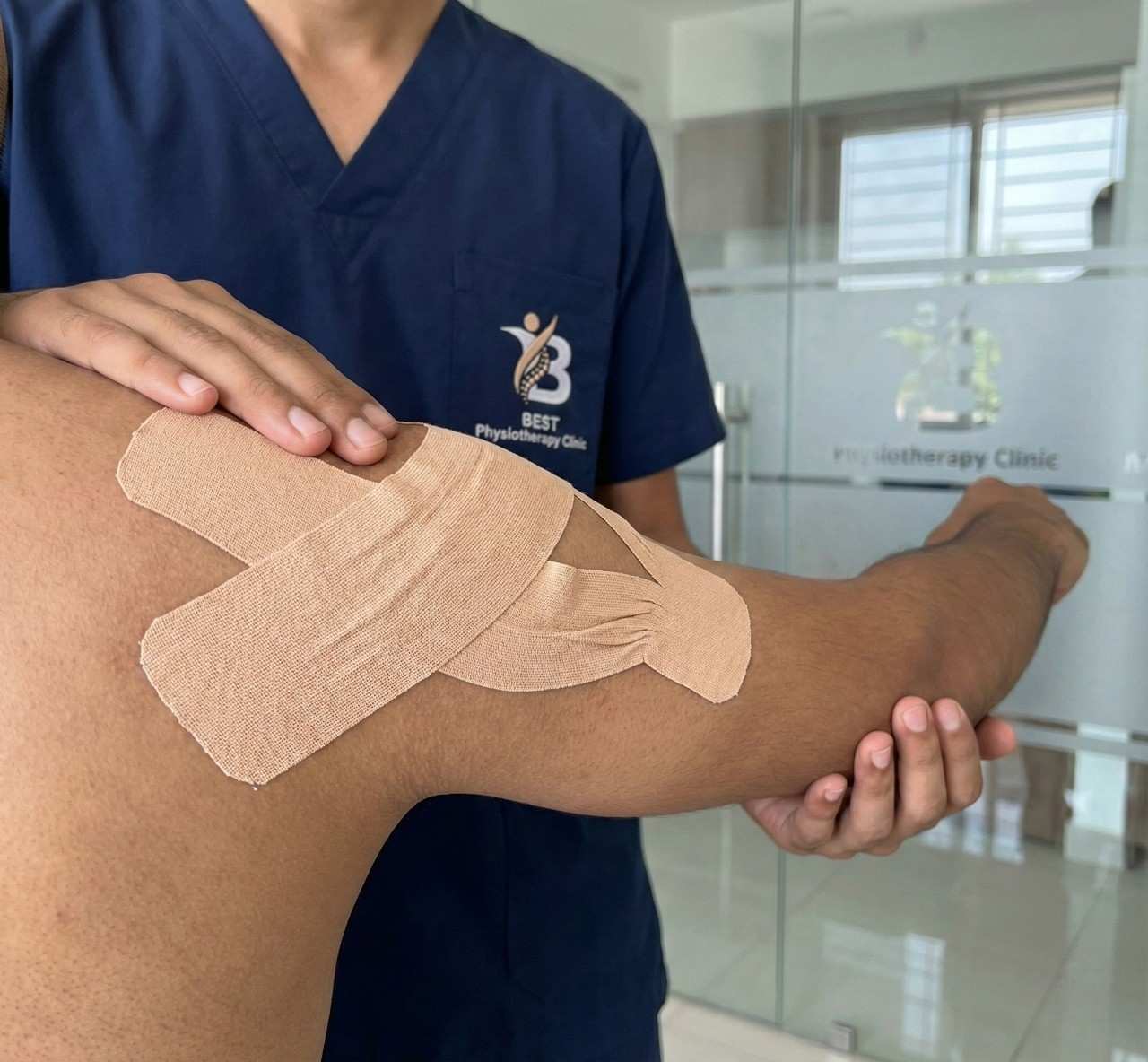 Physiotherapist consulting with a patient about Kinesio Taping benefits for muscle function and stability.